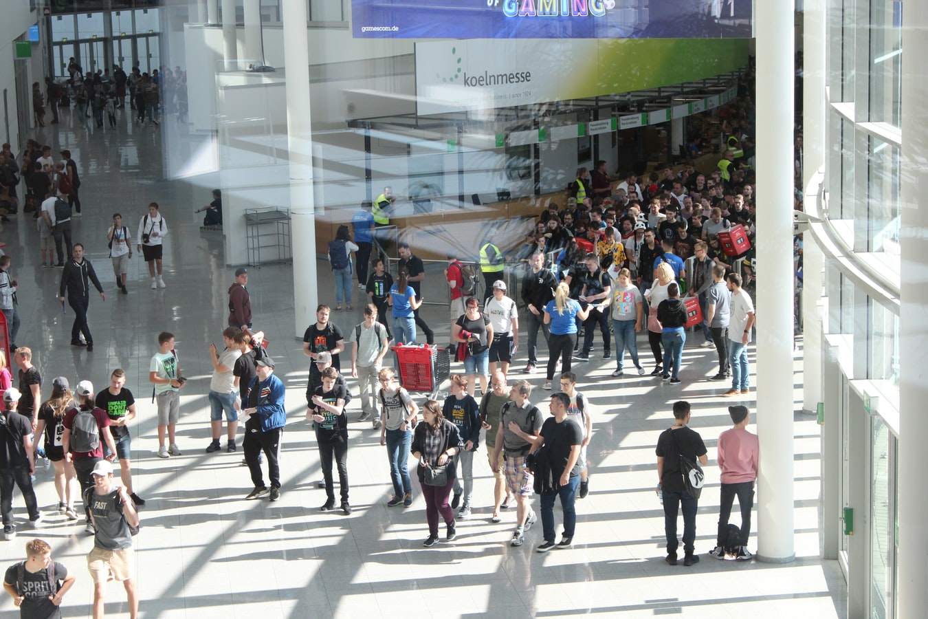 A crowd of people walking in a large, well-lit room.