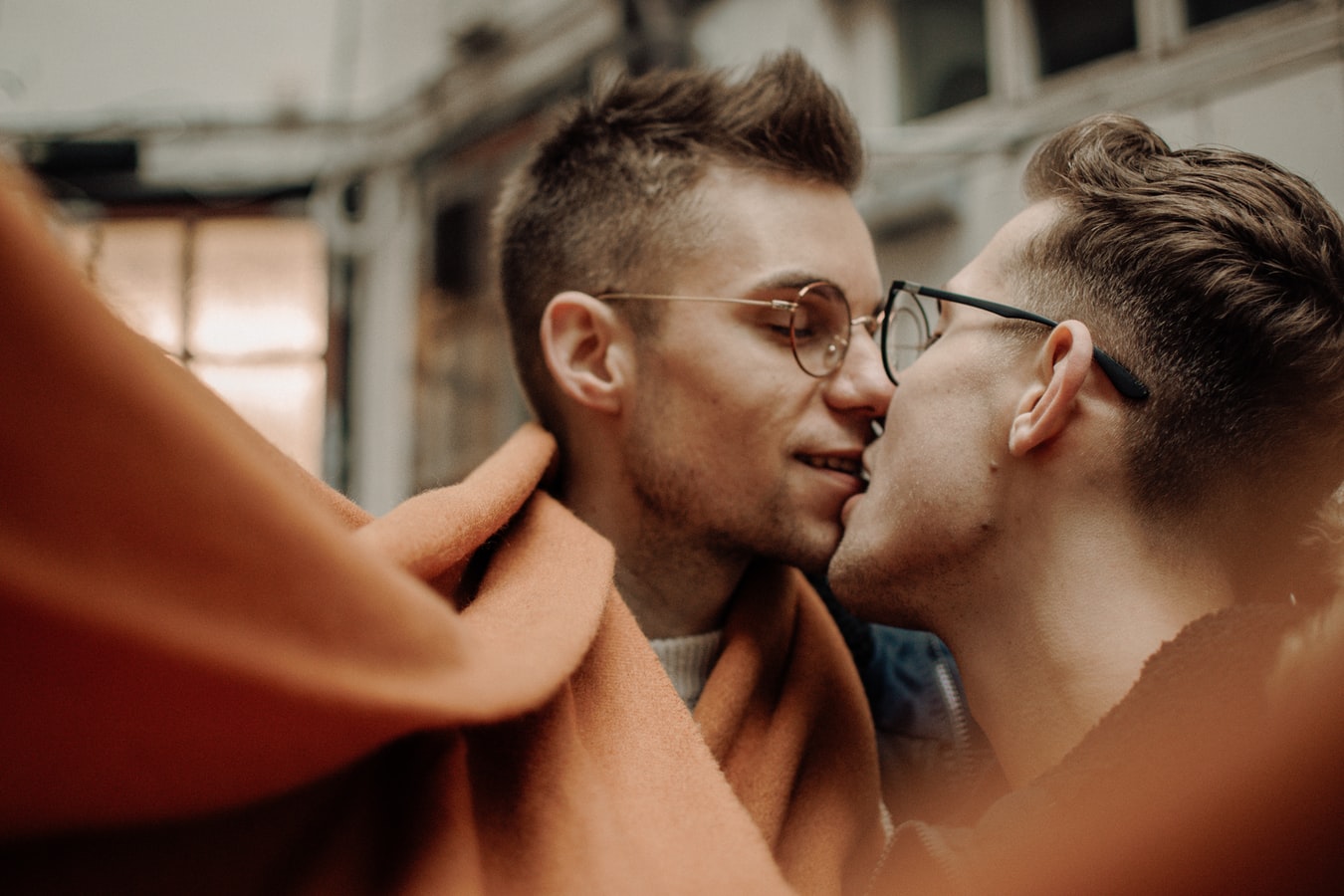 Two masc looking people kissing.