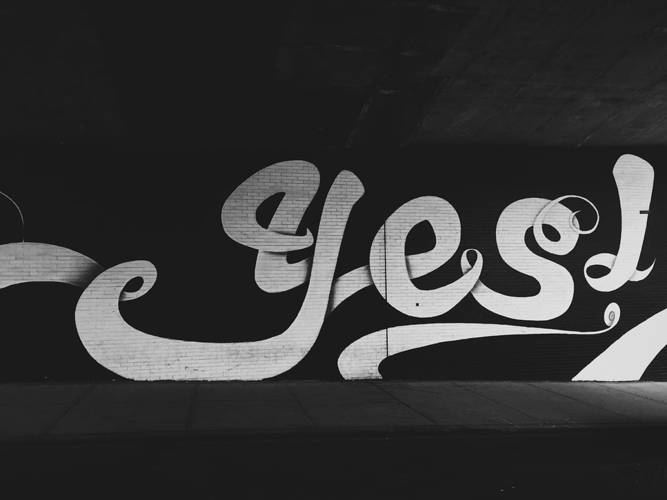 The word 'Yes' in fancy cursive swirling font.